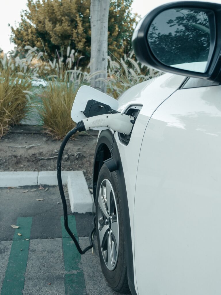 Bilden visar en elbil som laddas vid en ev laddstation, ladda elbil hemma med rätt laddstation typ 1 och typ med rätt laddningskablar typ 1 och typ 2