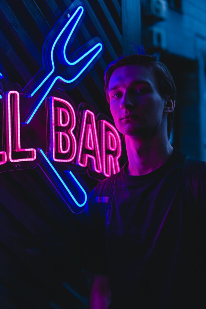 Bilden visar en person vid en neonskylt. Energieffektiva LED-skyltar och företagsskyltar kan ersätta gamla och föråldrade neonskyltars teknik.