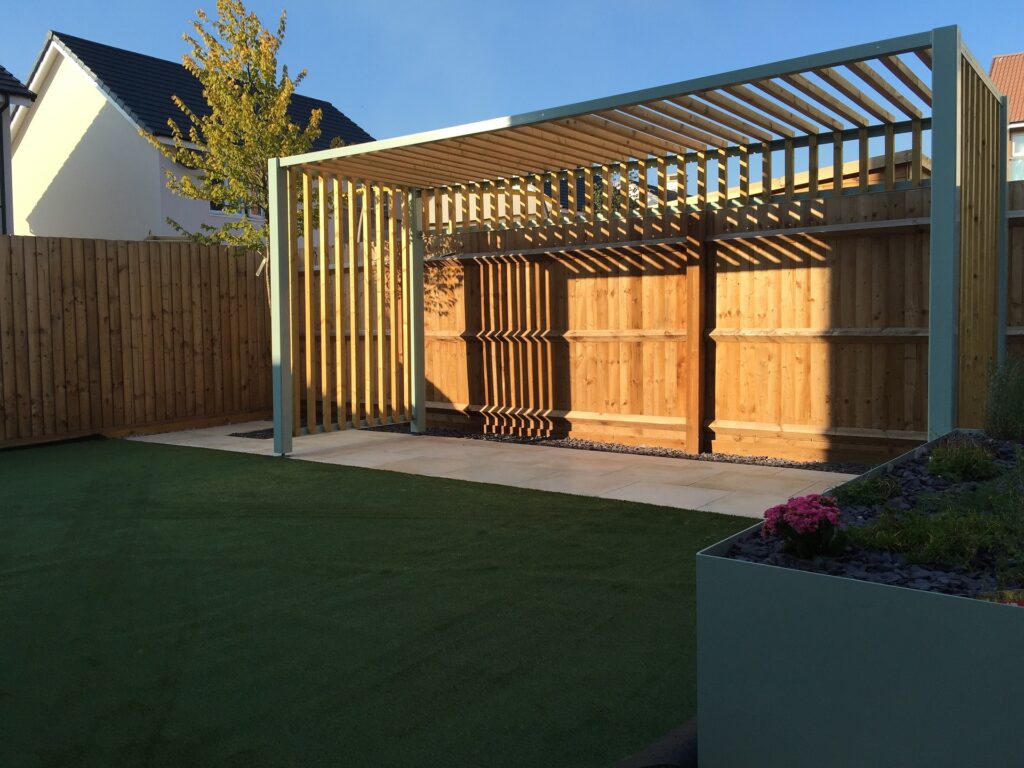 Bilden visar en pergola i trä. Med pergolamarkiser skapar du ett effektivt solskydd och kan skapa en pergola med tak.