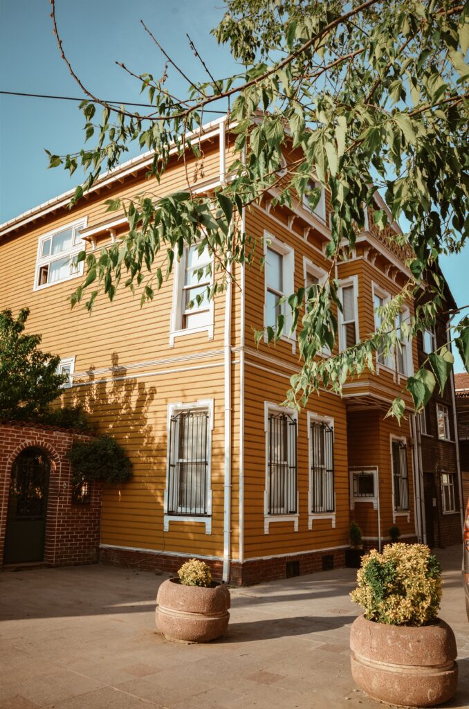 Bilden visar ett gult hus. En målerifirma i Norrköping kan hjälpa dig med tapetsering, fönsterrenovering, reparationsmålning och underhållsmålning i Norrköping.