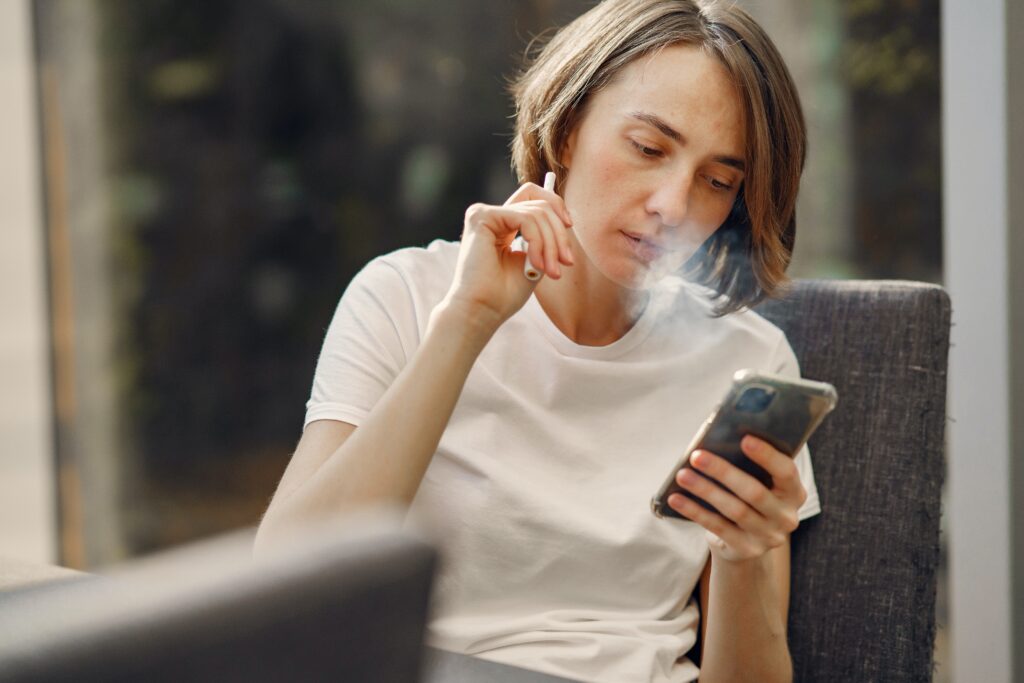 Bilden visar en person som använder en elektronisk cigarett eller e cigg. Vape har blivit alltmer populärt och engångsvejp kan minska nikotinberoendet.