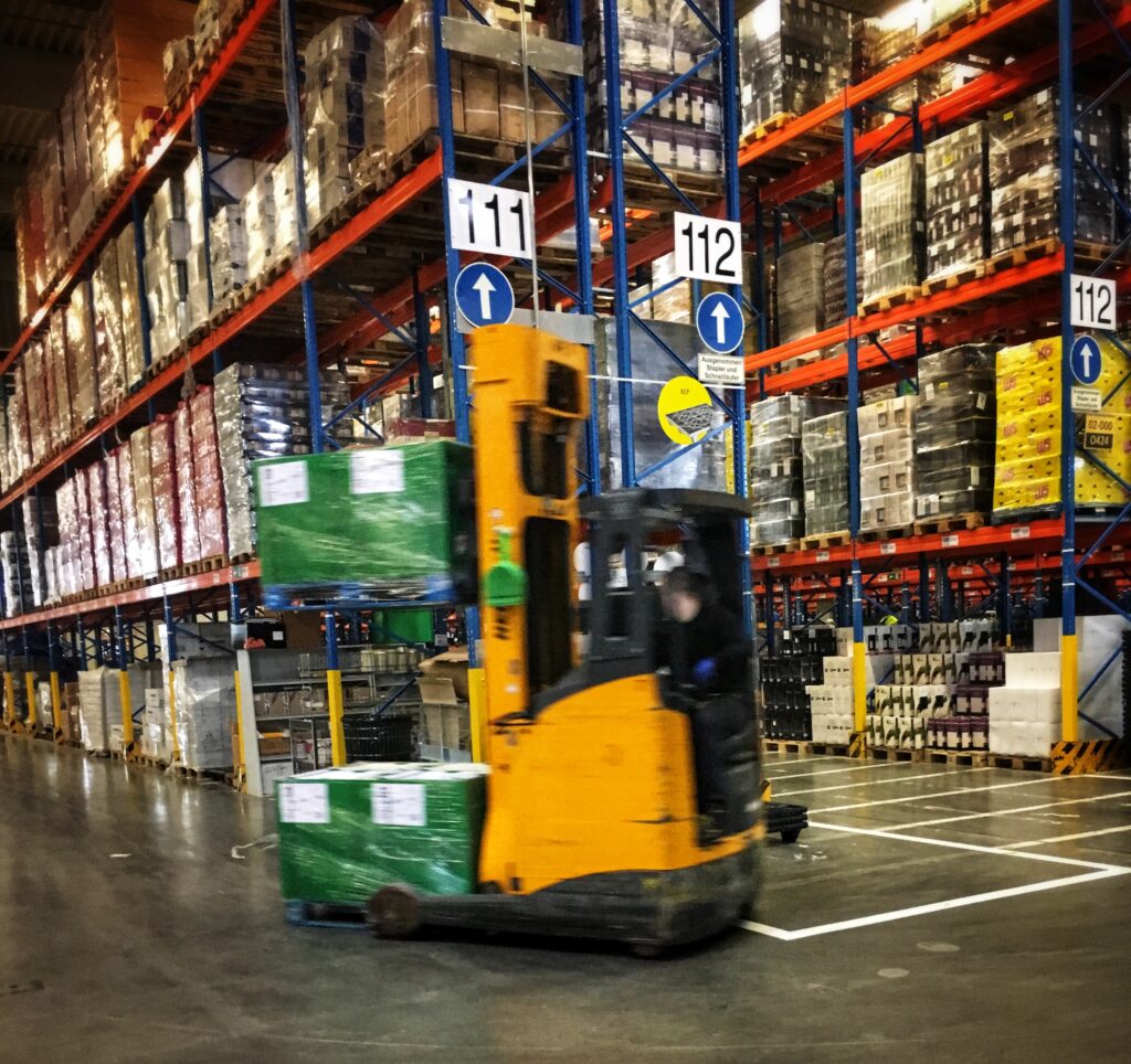 Bilden visar en truck på ett lager eller en industri. Trucckort finns för behörigheter som truckkort A och truckkort B men även för hjullastare.