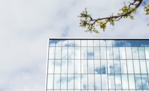 Bilden visar ett modernt hus med glasfönster. Energisparfilm kan användas för att spara in på energi.